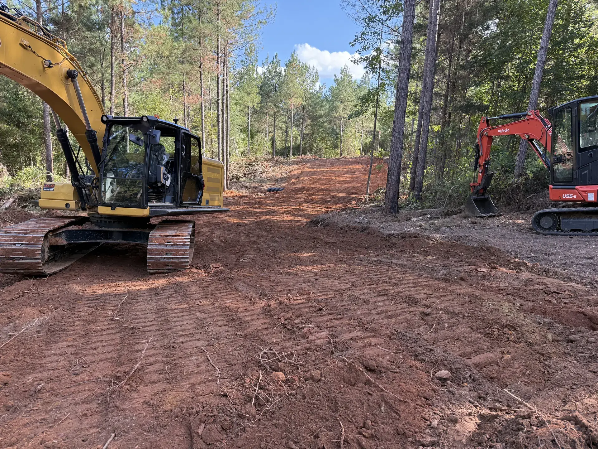 Excavator clearing trees and brush from a wooded property